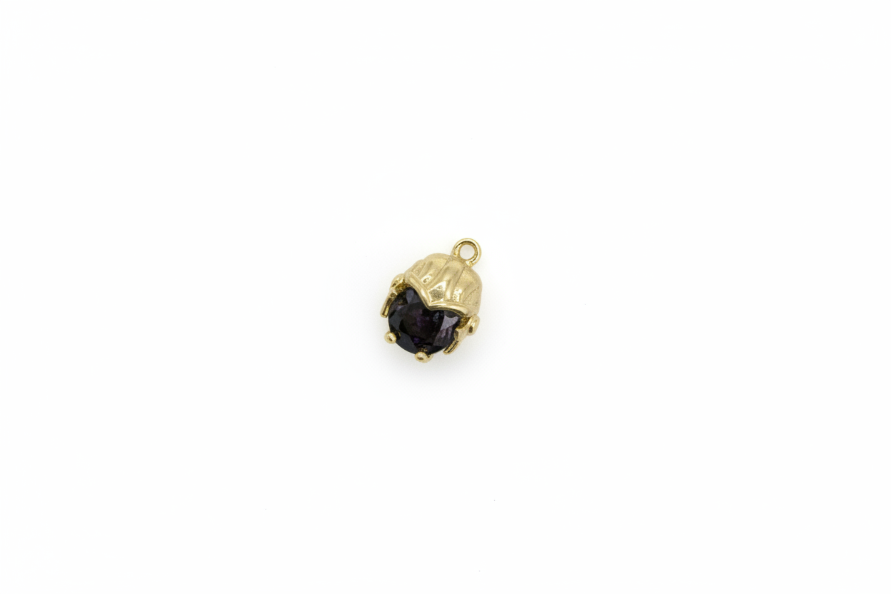 Gold scallop shell with faceted deep purple gem