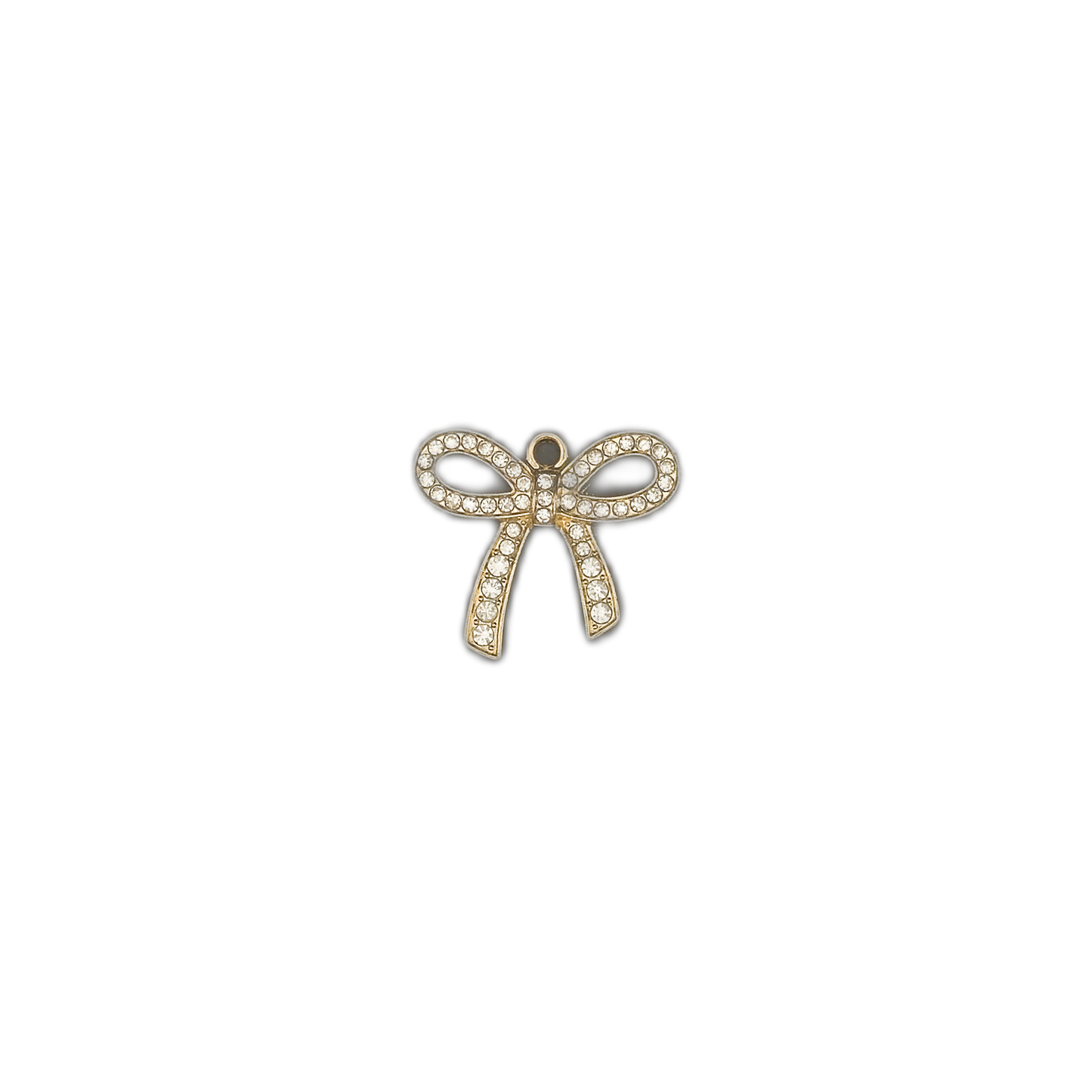 Small gold bow-shaped rhinestone charm centered on a black background.