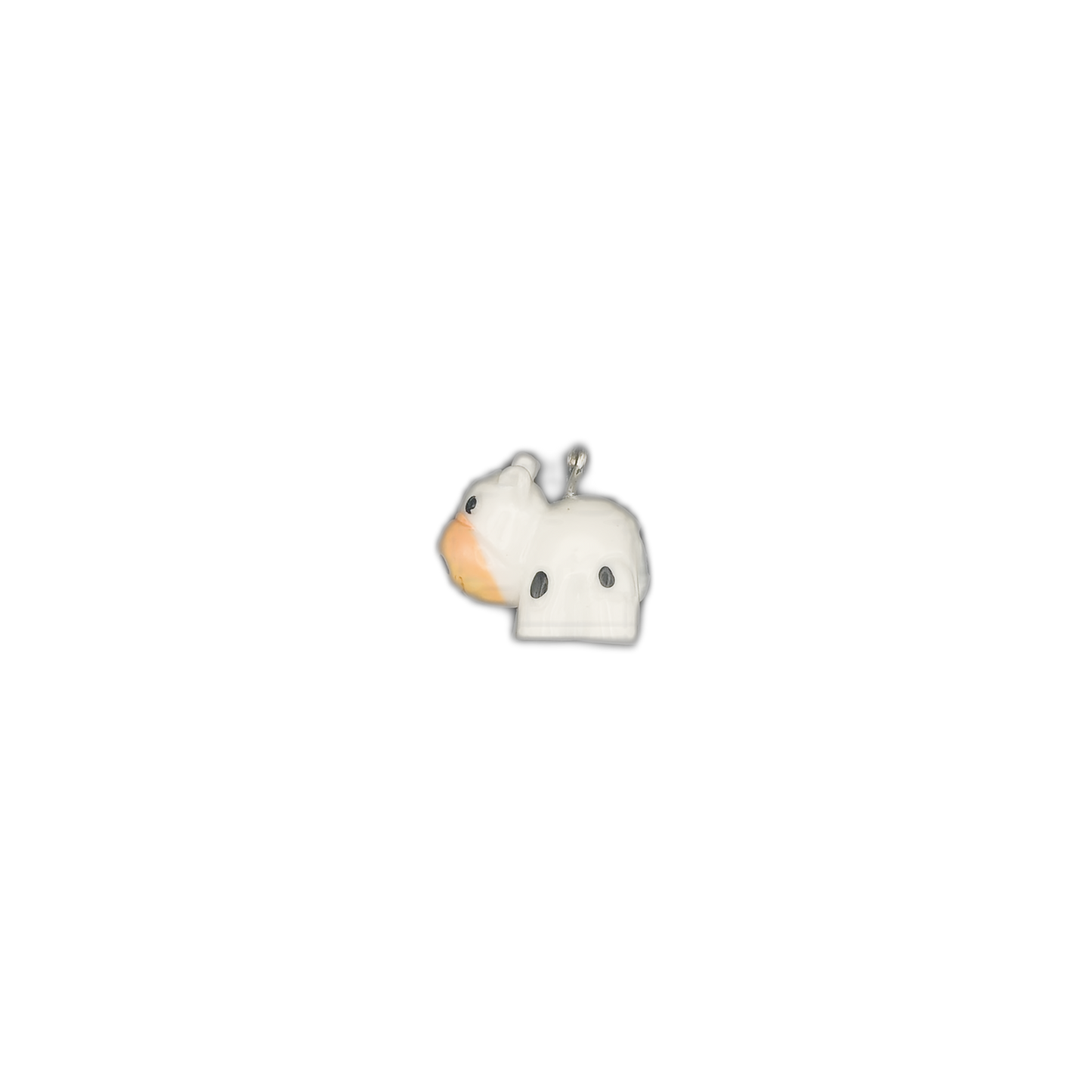 small cow charm in white with black spots, centered on a black background