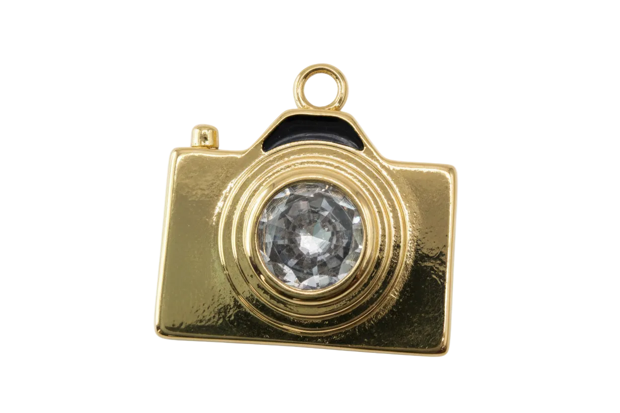 Gold camera charm with faceted clear gem lens and high-polish finish
