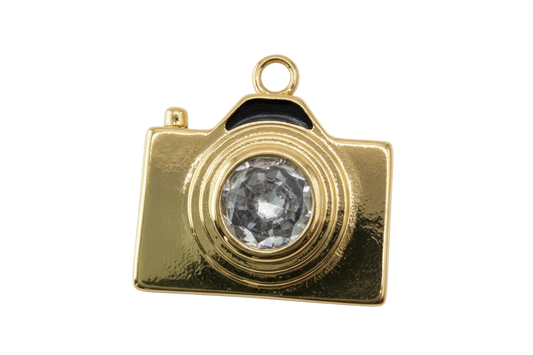 Gold camera charm with faceted clear gem lens and high-polish finish