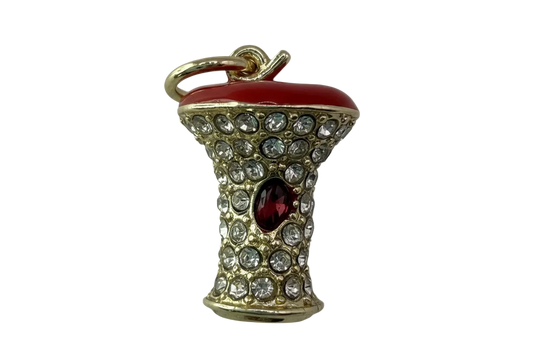 Gold mushroom charm with glossy red cap, clear crystals, and red oval gem accent