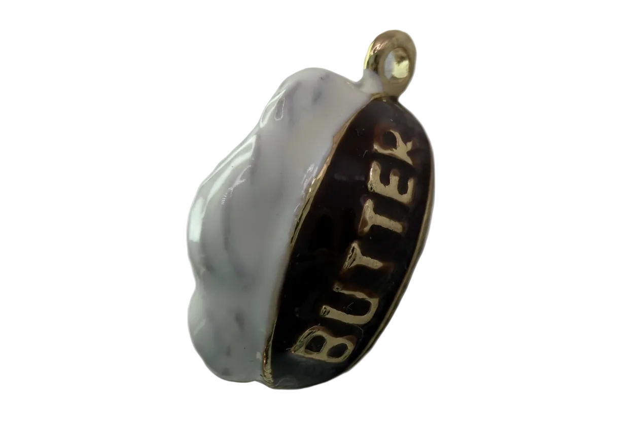 Black and white enamel oval with raised gold BUTTER lettering and gold edge