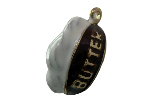 Black and white enamel oval with raised gold BUTTER lettering and gold edge