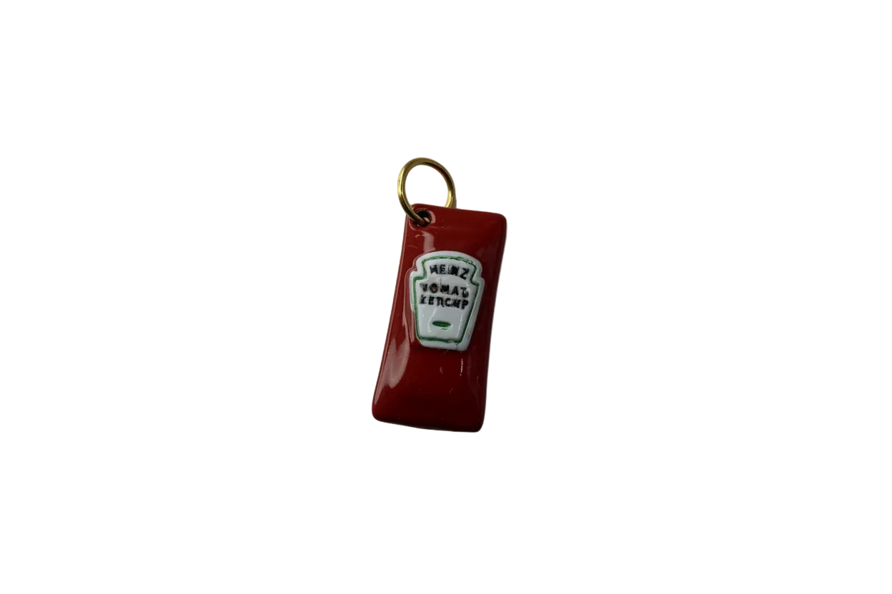 Red ketchup bottle charm with white label and gold top