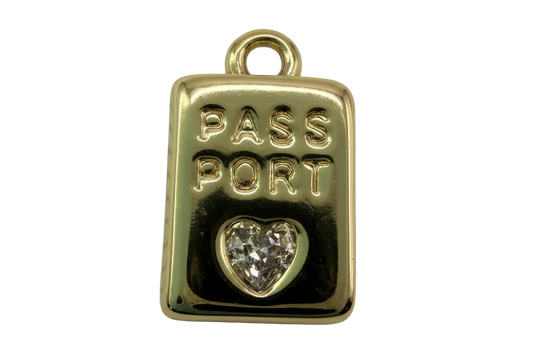 Gold passport tag with raised PASS PORT lettering and a clear heart-shaped faceted gem