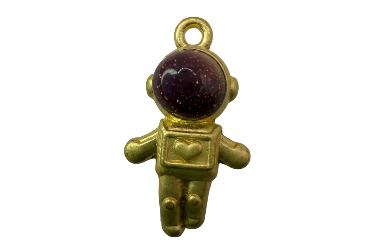 Gold astronaut figure with glossy deep-plum glitter helmet and heart detail