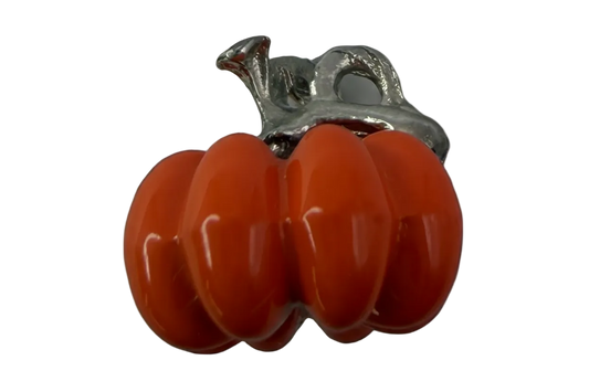 Glossy orange pumpkin charm with silver-tone stem on a black background