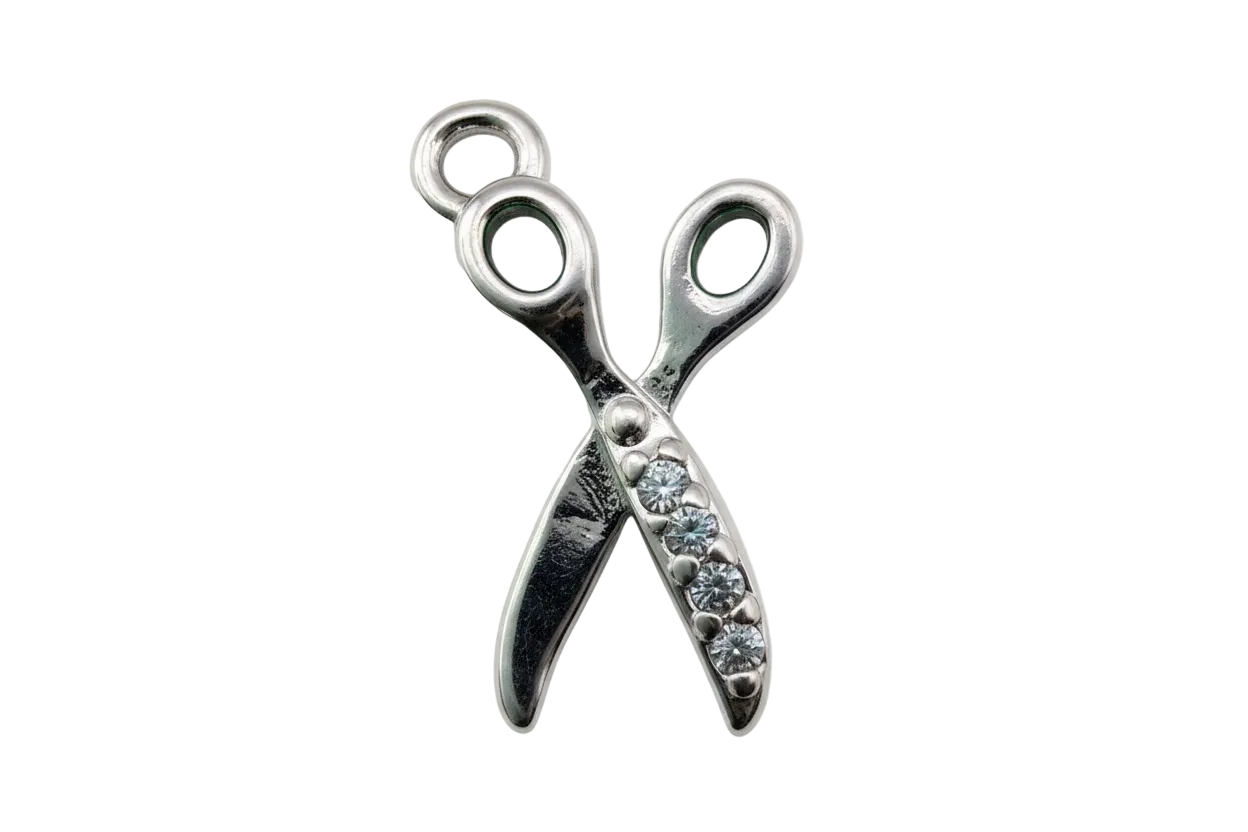 Polished silver scissors charm with clear pavé crystals on one side, isolated on black