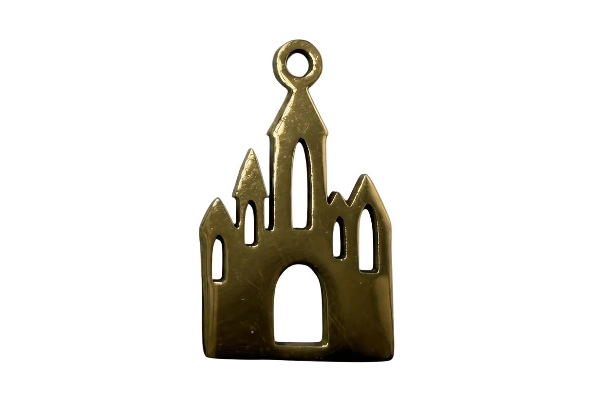 Gold gothic cathedral silhouette charm with arched window cutouts and tall spires