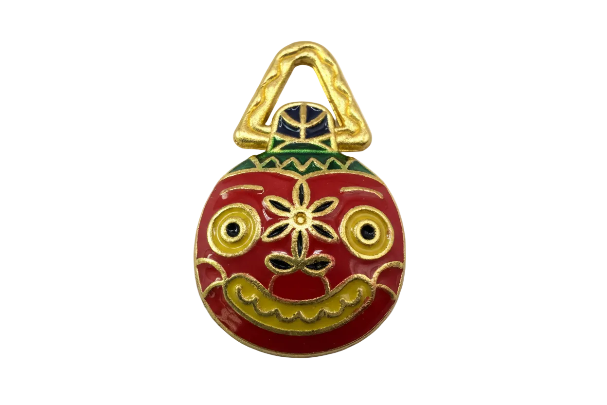 Red enamel folk mask with gold detailing, green accents, and yellow eyes