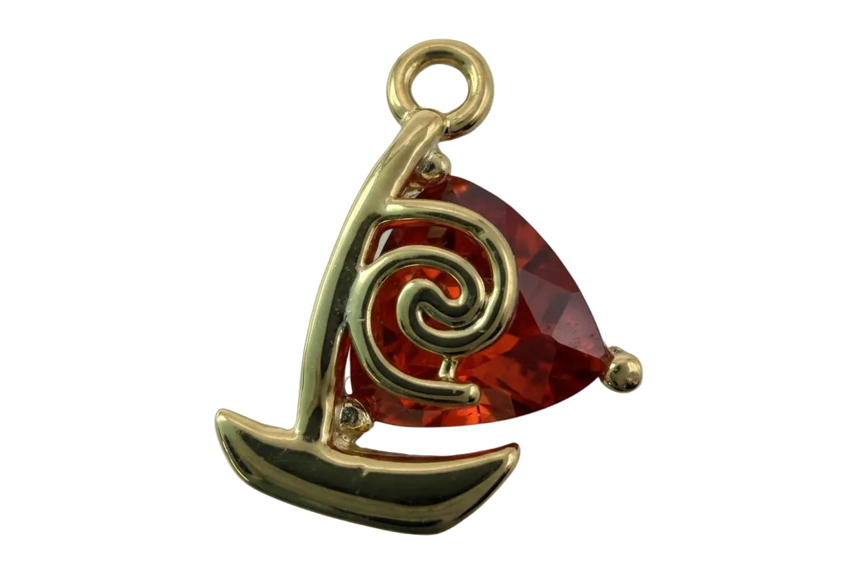 Gold sailboat charm with faceted red gem sail and swirl detail