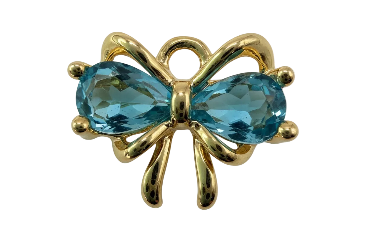 Gold bow knot with two faceted aqua-blue oval gems