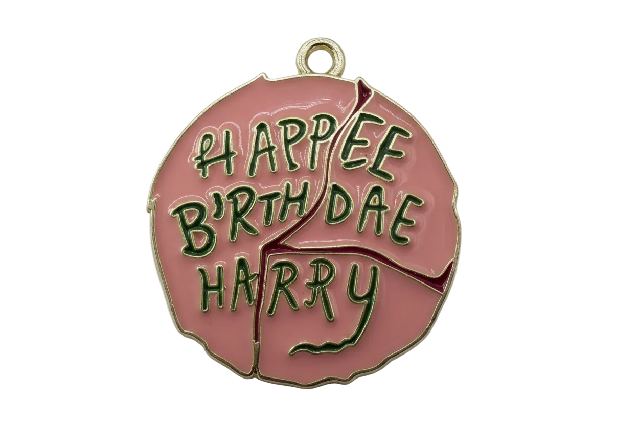 Pink enamel disc with raised green "Happy Birthday" lettering and gold outline