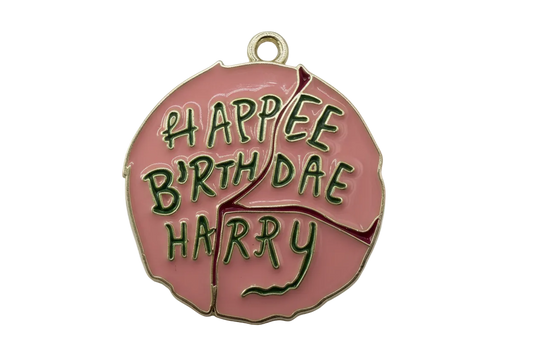 Pink enamel disc with raised green "Happy Birthday" lettering and gold outline