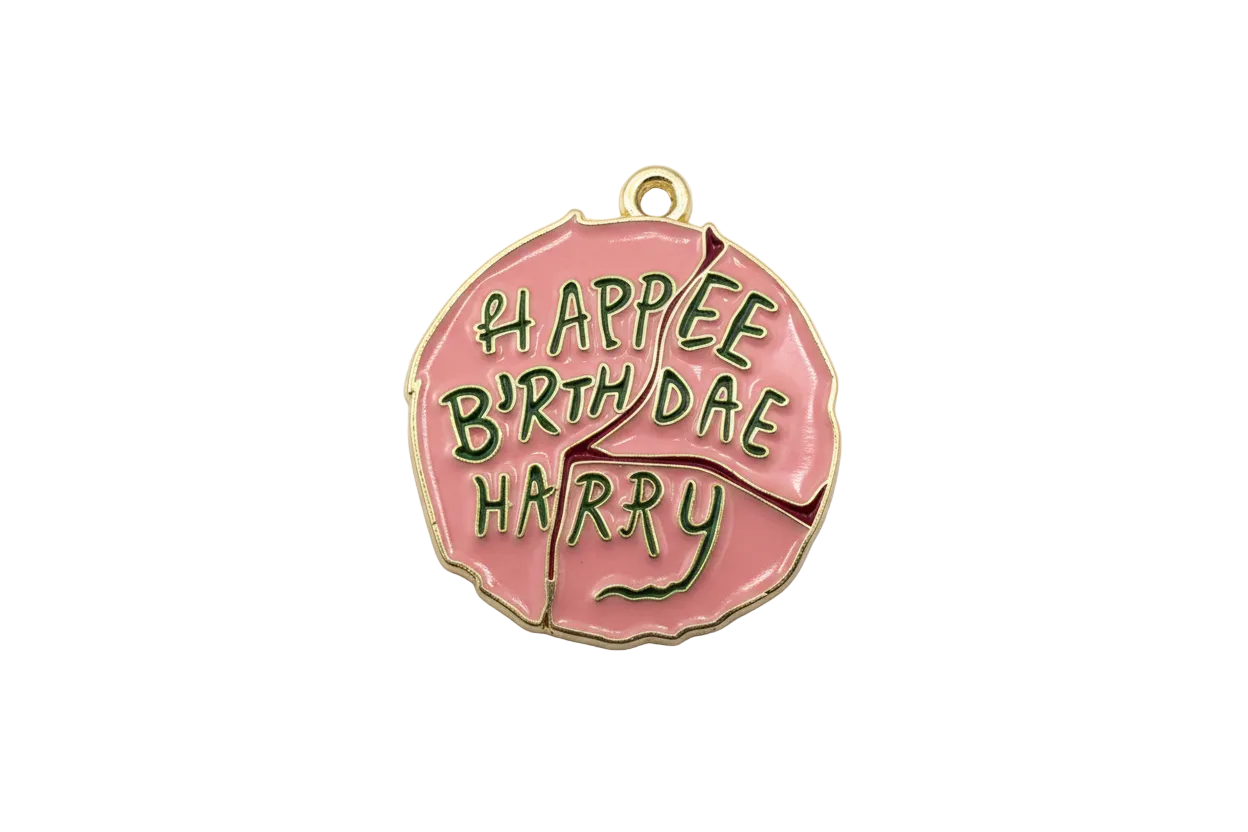 Pink disc with raised green Happy Birthday lettering in gold outline