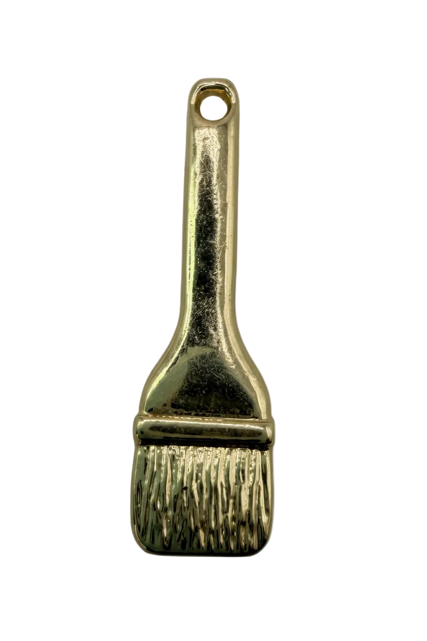 Glossy gold paintbrush charm with textured bristles and smooth handle