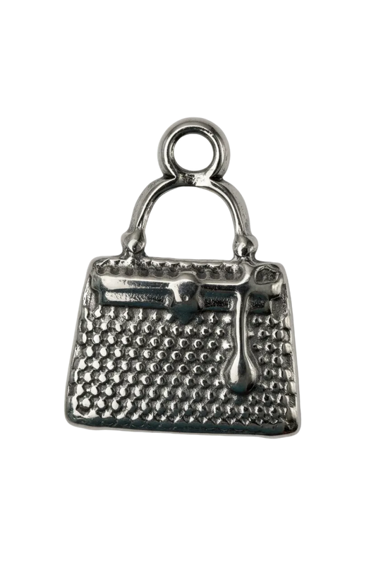 Silver handbag pendant with textured surface and curved handle