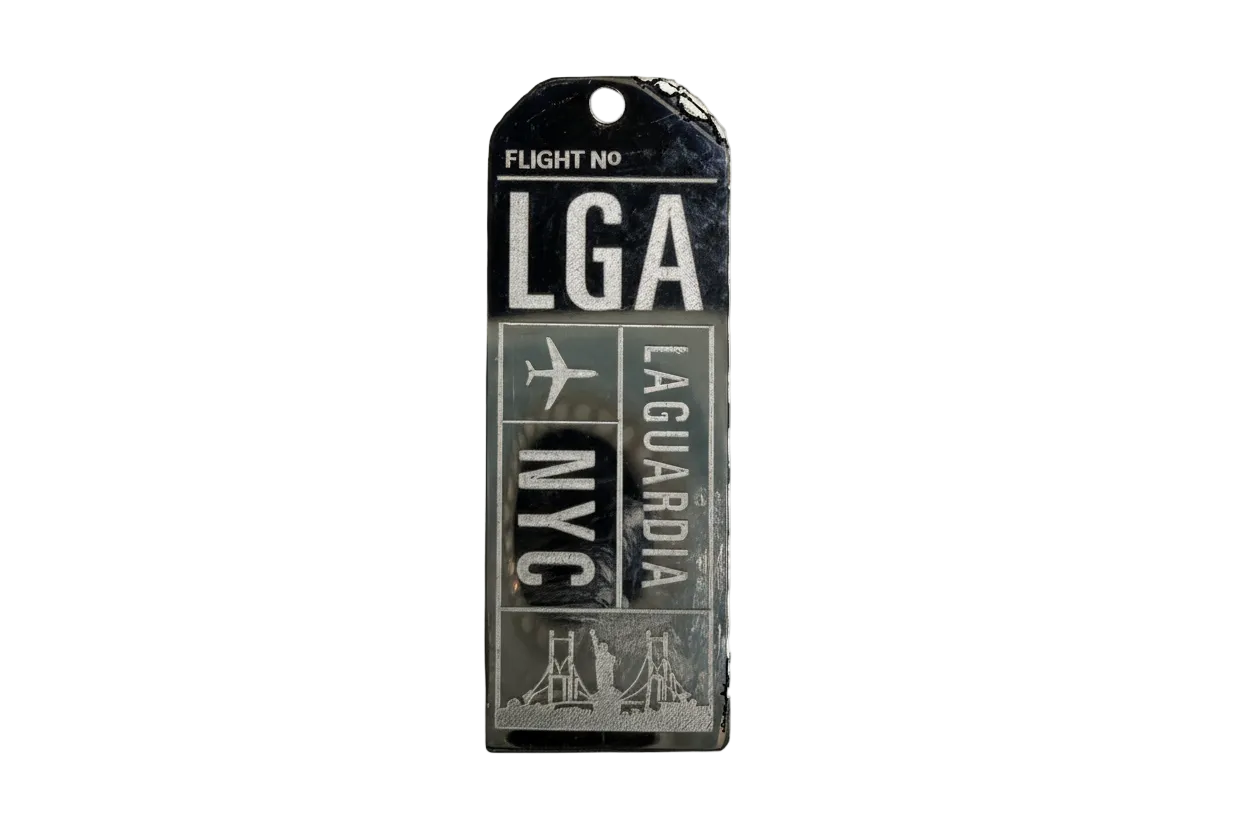 Black and silver airport code ticket tag with plane icon and skyline graphic