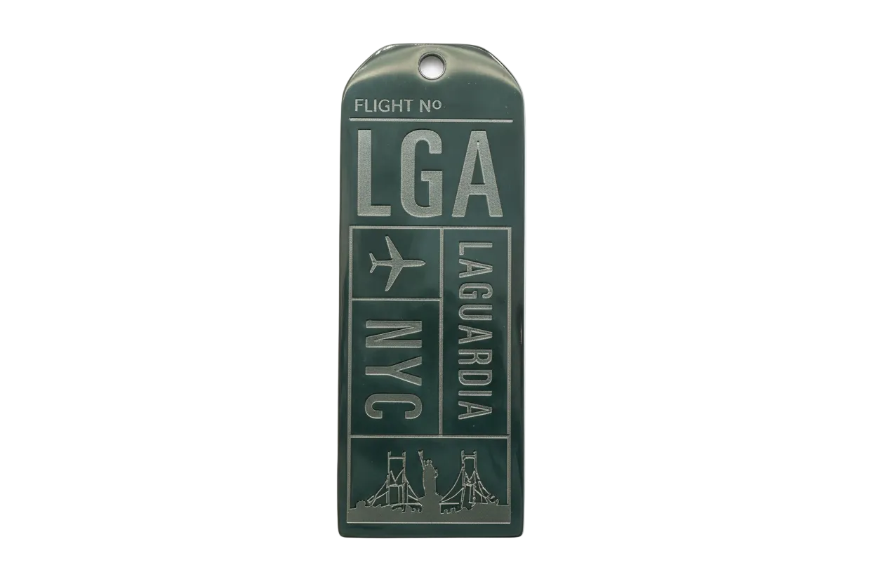 Rectangular silver tag with glossy dark green enamel, raised airport-style lettering and an airplane icon