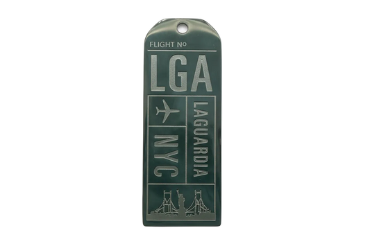 Rectangular silver tag with glossy dark green enamel, raised airport-style lettering and an airplane icon