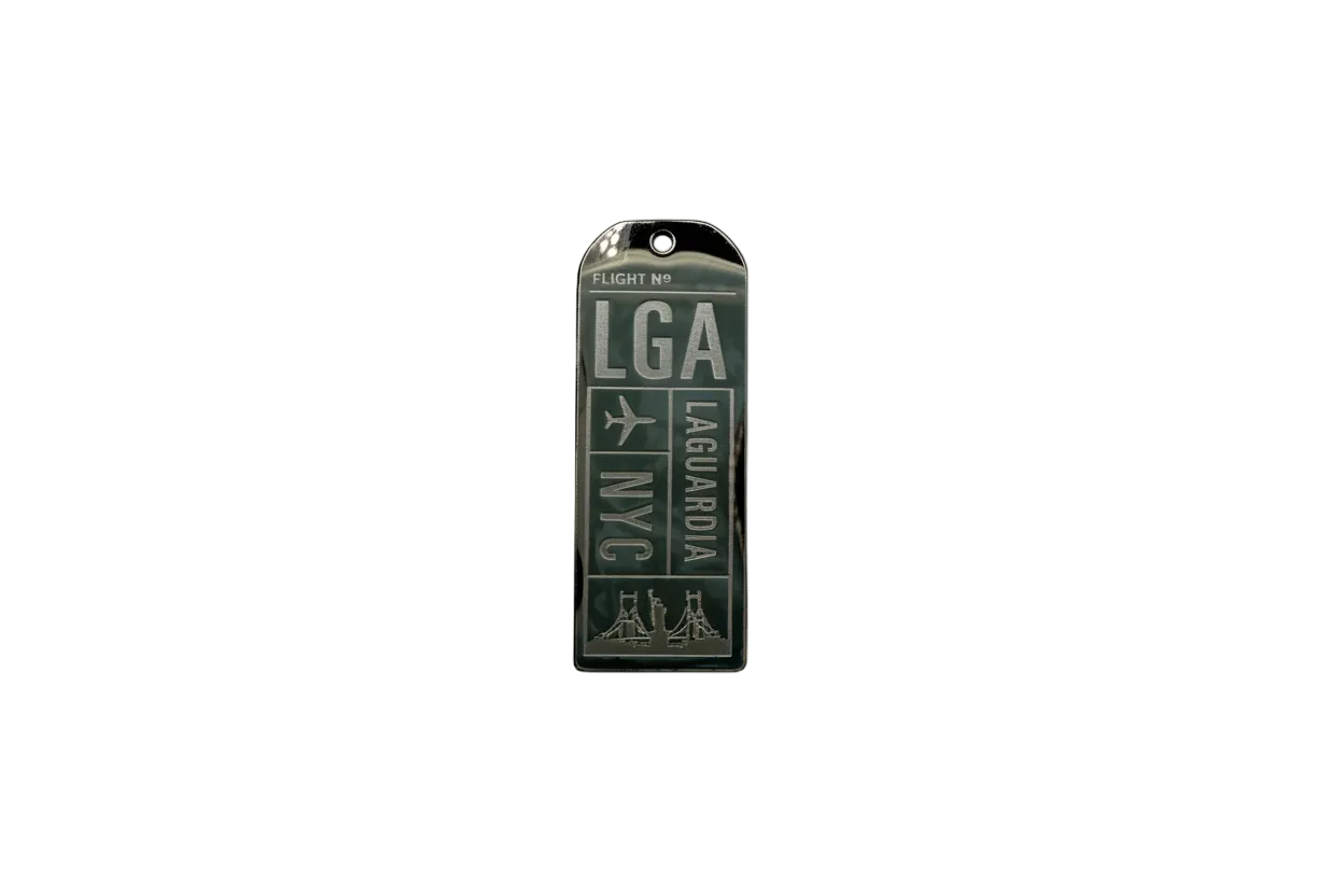 Silver airport-style tag with dark green enamel and airplane icon