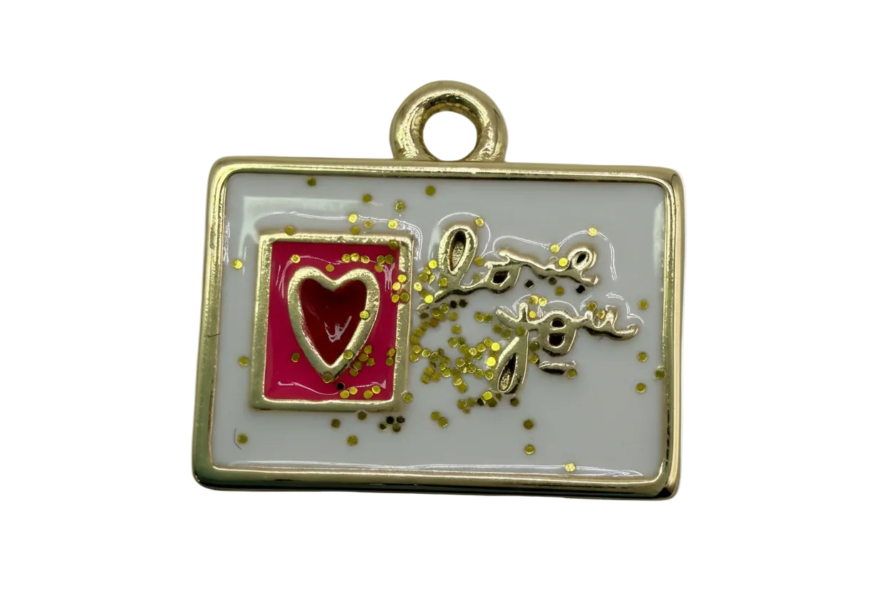Gold-framed white enamel rectangle with raised 'love you' script, pink panel, red heart, and gold confetti