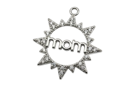 Silver sunburst medallion with clear crystals and raised “mom” over white patterned enamel