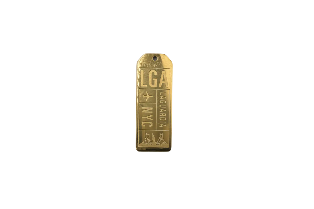 Gold engraved travel tag with airplane and skyline
