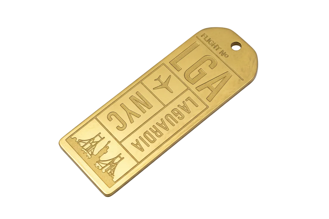 Gold engraved airport boarding pass tag with LGA and NYC lettering, airplane icon, and skyline motif