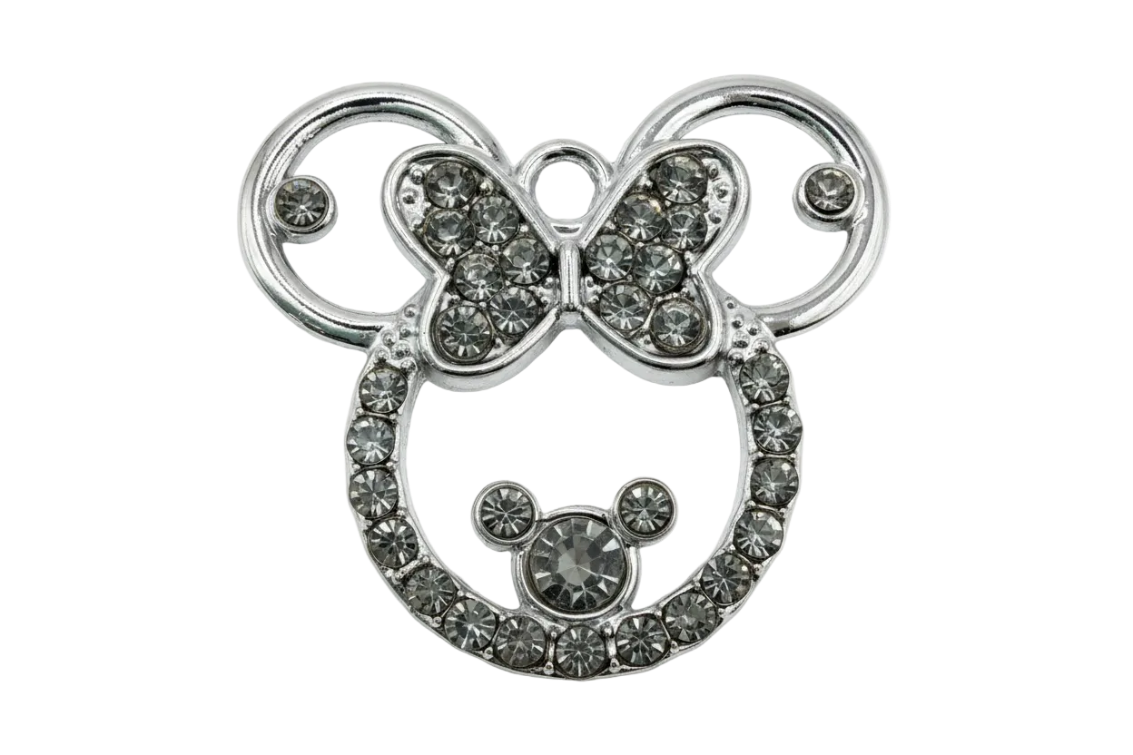 Silver mouse head silhouette with bow, outlined in clear crystals on polished metal