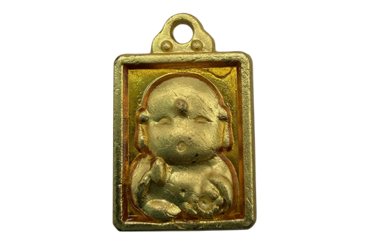 Gold rectangular plaque with raised seated baby figure and amber-toned background