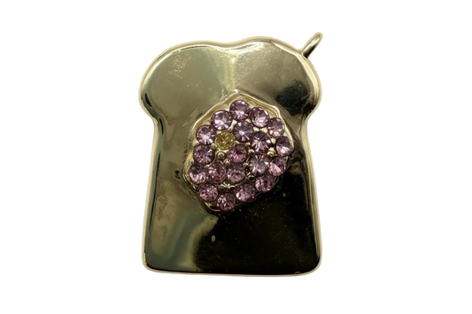 Polished gold toast slice with clustered faceted purple crystals at center