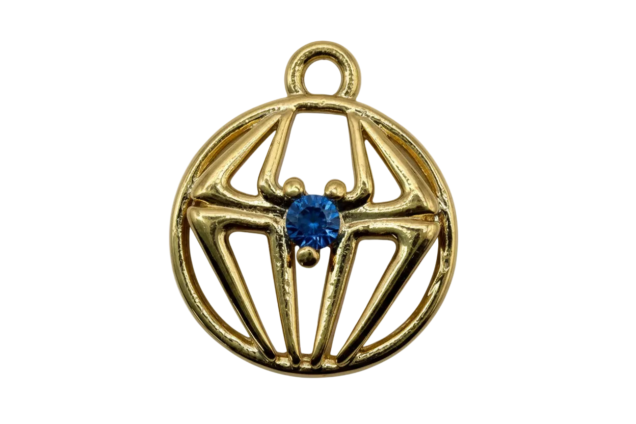 Gold openwork spiderweb round medallion with ivory marbled inlay and cobalt blue center gem