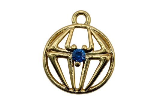 Gold openwork spiderweb round medallion with ivory marbled inlay and cobalt blue center gem