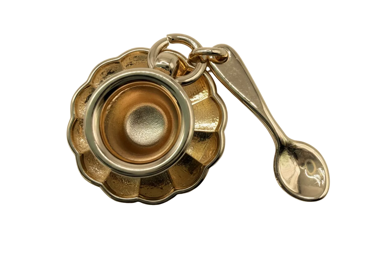 Polished gold scalloped bowl with attached spoon charm on black background