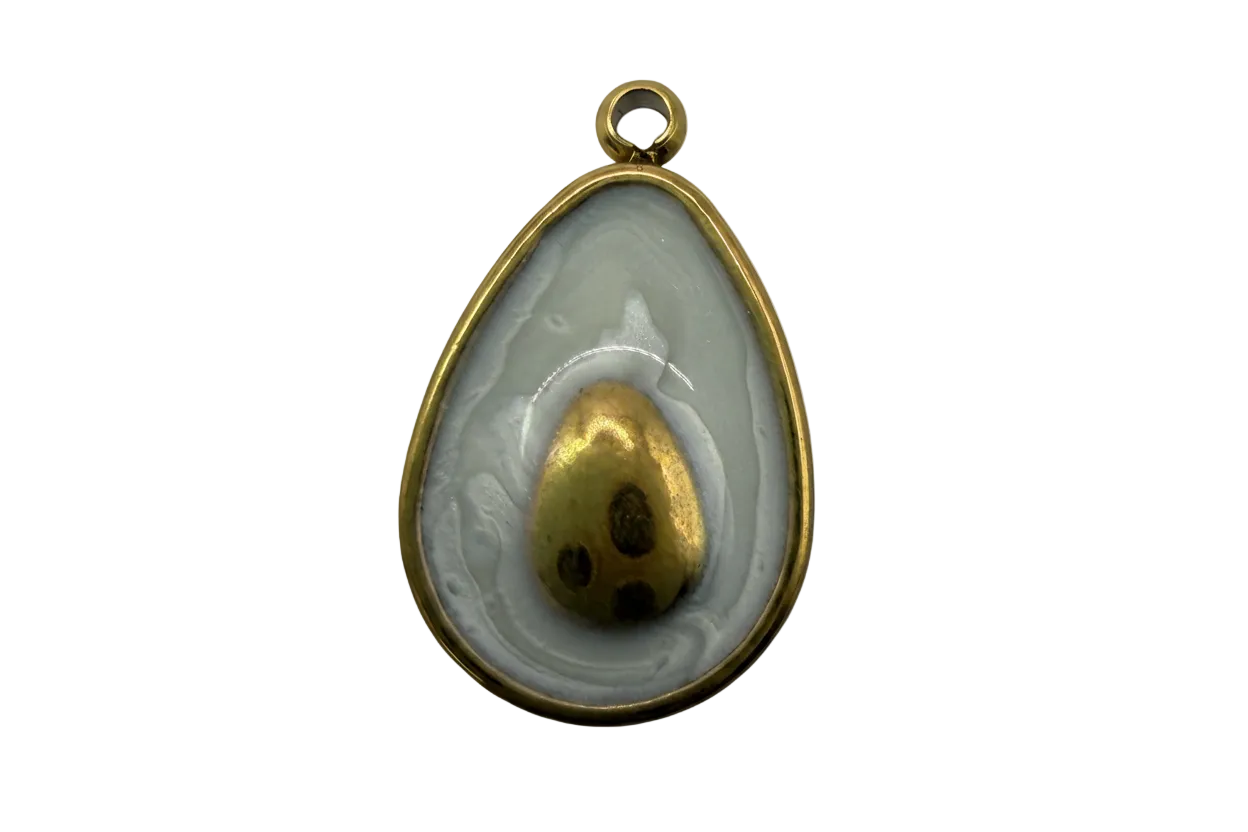 Fried egg medallion with marbled gray-white enamel and gold yolk detail, gold-tone frame