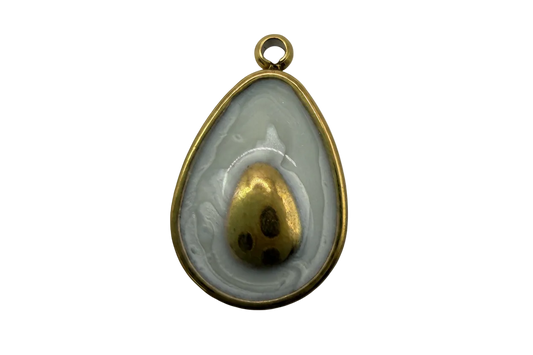 Fried egg medallion with marbled gray-white enamel and gold yolk detail, gold-tone frame