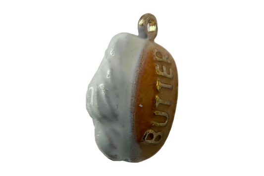 Glossy butter biscuit charm in gold with white icing and raised BUTTER lettering