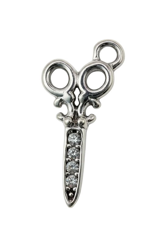 Polished silver scissors motif with clear crystal accents on the blade