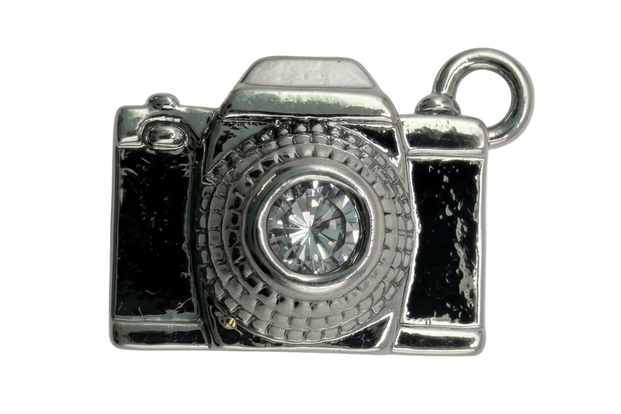 Polished silver camera charm with a clear faceted crystal lens on black background