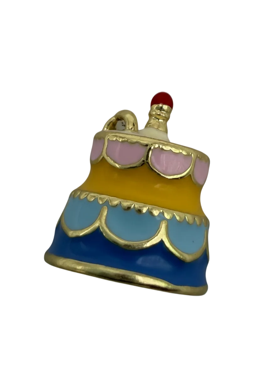 Pastel frosted cake slice in blue, yellow, and pink enamel with gold outlines and a small red topper