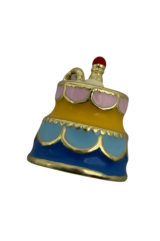 Pastel frosted cake slice in blue, yellow, and pink enamel with gold outlines and a small red topper