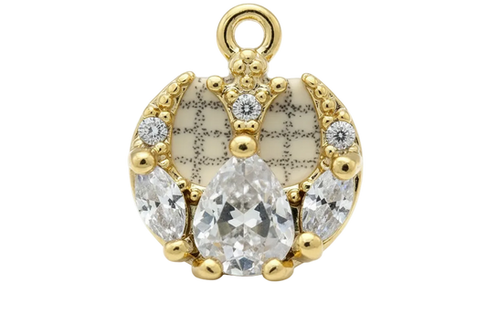 Gold horseshoe charm with ivory speckled enamel and clear faceted crystals