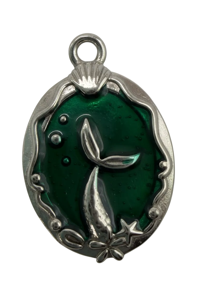 Emerald green translucent oval charm with silver whale tail, star, and comet details