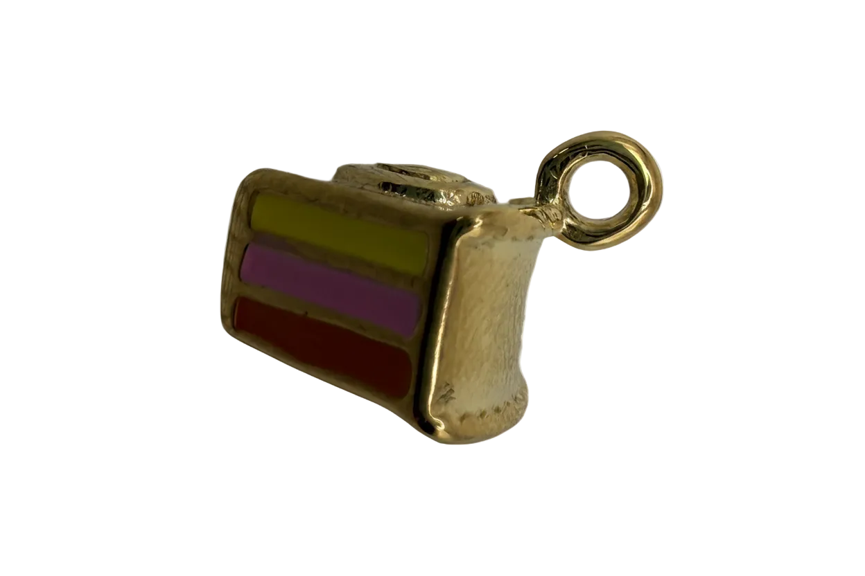 Gold cake slice charm with green, purple, and red enamel layers and a whipped cream top