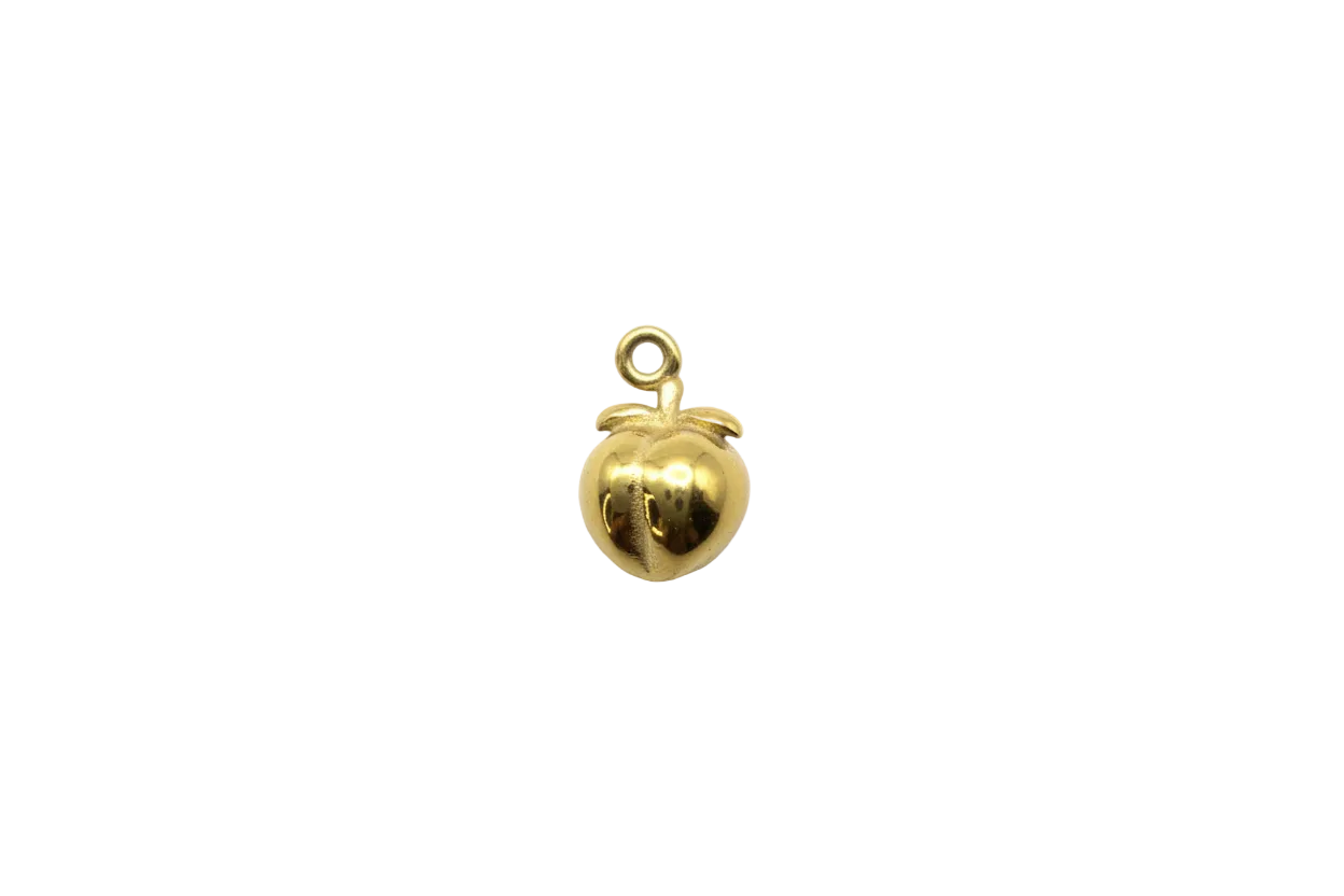 Polished gold peach fruit with sculpted leaf
