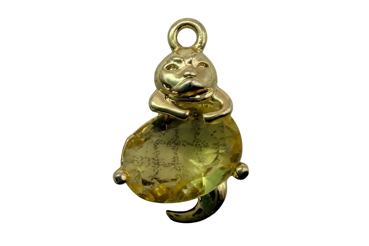 Polished gold bear holding a faceted oval yellow gem with subtle dark inclusions