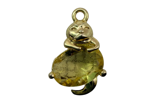 Polished gold bear holding a faceted oval yellow gem with subtle dark inclusions
