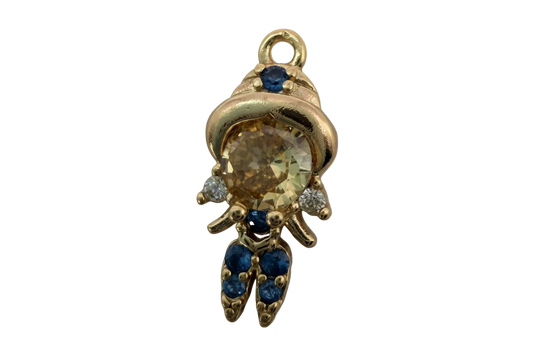 Gold astronaut figure with champagne faceted gem center and blue and clear gem accents